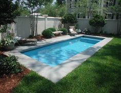 a backyard with a swimming pool surrounded by grass