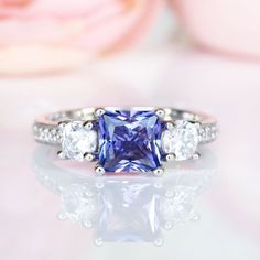 Gorgeous Princess Tanzanite Ring ►Made of sterling silver, rhodium plated (S925) ►Center stone: Tanzanite Color: Purple Gemstone Creation: Simulated Cut: Princess Gem size: 6.0 mm Carat Weight: 1.2 ct. (approx.) ►Accented with simulated diamonds (CZ) Cut: Round Gem size: 1.0 mm- 4.0 mm Color: Colorless ►Bands width: 2.4 mm ✓ 100% Nickel-Free ✓ Hypoallergenic ✓ Comfort Fit ✓ Free Ring Box ✓ Free USA Shipping ✓ Ready to ship next business day Rings Engagement Set, Etsy Engagement Rings, Princess Cut Engagement Ring, Gifts For Anniversary, Gift Ideas Wedding, Popular Engagement Rings, Princess Cut Engagement, Women's Spurs, Jewelry Gift Ideas