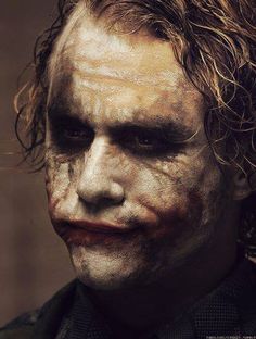 a close up of a person with makeup on and hair in the shape of a joker