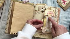 a person is making a scrapbook with paper and buttons on the pages, which are decorated with flowers