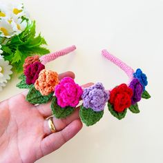 a hand holding a crocheted flower headband