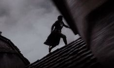 a woman standing on top of a roof