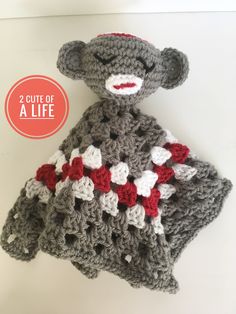 there is a crocheted stuffed animal that looks like a teddy bear with red and white flowers on it