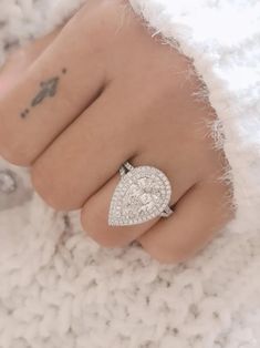 a close up of a person's hand with a diamond ring on their finger