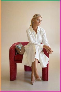 a woman sitting on top of a red couch