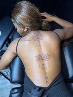 a woman sitting in a chair with a tattoo on her back