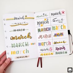 a hand holding a planner with months and month markers on the pages in front of it