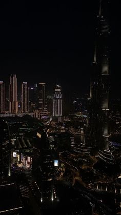 the city is lit up at night with skyscrapers and other buildings in the background