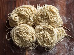 four uncooked noodles sitting on top of a wooden table