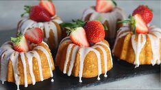 small cakes with strawberries on top and icing drizzled over them