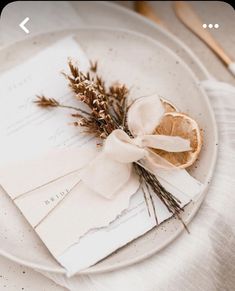 a white plate topped with an orange slice next to a piece of paper on top of a table