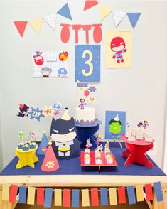 the table is set up for a birthday party with colorful decorations and paper cutouts