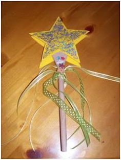 a wooden stick with a star on it and some ribbons around the top, sitting on a table