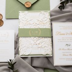 the wedding stationery is laid out on top of each other, including an envelope and two wax stampers