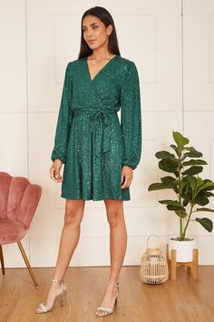 Festive partywear is here. Make an entrance in this Mela Green Sequin Wrap Dress. Incredibly flattering, this wow-factor dress benefits from a wrap around shape, matching sequin tie and long sleeves. Match with silver accessories for an unforgettable look. Sequin Wrap Dress, Work Wear Outfits, Dresses Green, Maxi Bridesmaid Dresses, Shape Matching, Lace Skater Dress, Floral Shirt Dress, Green Sequins, Puff Sleeve Dresses