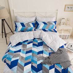 a bed with blue and grey chevroned comforter set on top of it