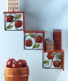 apples are sitting in a wooden bowl on the wall