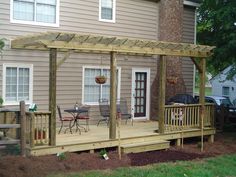 a large house with a covered deck in front of it and a car parked outside