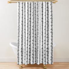 a black and white shower curtain hanging on a wall next to a bathtub in a bathroom