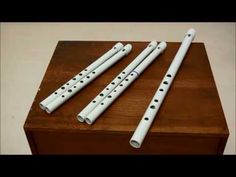 three white flutes sitting on top of a wooden box