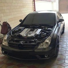 a black car with its hood open and engine in the middle of it's body