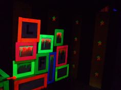 the room is lit up with bright colors and stars on the walls, along with neon colored frames