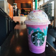 a starbucks drink with whipped cream and sprinkles on the top sitting on a counter