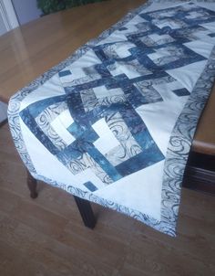 a quilted table runner sitting on top of a wooden table