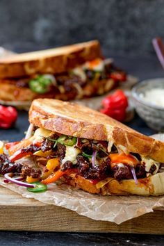 the sandwich is cut in half and ready to be eaten on the table with other food items