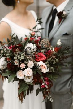 the bride and groom are standing close to each other with their wedding bouquet in hand