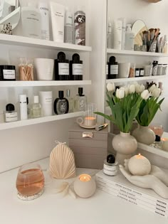 a white counter topped with lots of bottles and candles