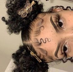 a close up of a person with tattoos on her face and curly hair in a bun