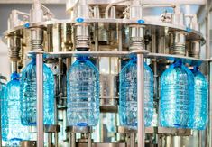 bottles are being filled with water in a factory