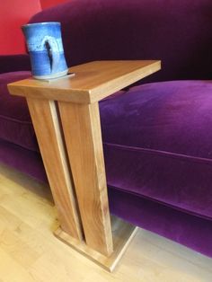 a purple couch sitting next to a wooden table