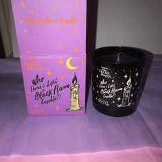 a candle and box sitting on a purple tablecloth with the words what does it look like?