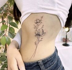 a woman with a flower tattoo on her lower back and the bottom part of her stomach