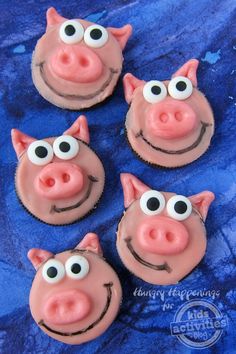 four cupcakes decorated to look like pigs with googly eyes