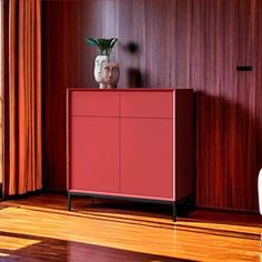 a red cabinet sitting on top of a hard wood floor next to a white chair