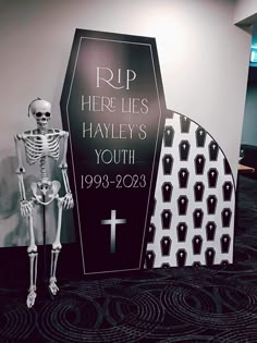 a skeleton standing in front of a tombstone with a cross on it's side