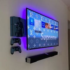 a flat screen tv mounted to the side of a wall next to two video game controllers