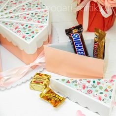 an assortment of chocolates and candy bars in a gift box on a white table