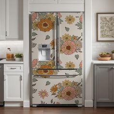 a floral refrigerator in a kitchen with white cabinets and wood flooring on the walls