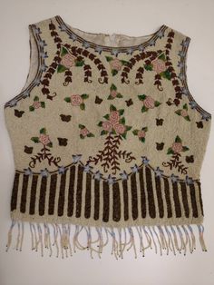 "Incredible detail and beadwork coverage on this vintage 80's beaded top. Artist design with flowers and stripes on the lower band. Front on photographs show it pulling in around the waist, it hangs that way naturally, look also at the side view and flat view. Has beaded finge at hem. Only loss found is on the fringe. Needs three fringe strands recreated to be 'bead perfect', 4 missing. Coth backing sturdy and zipper great. There is some discoloration on lining - please see photo. Size marked Me Vintage Beaded Tops For Summer, Vintage Beaded Fitted Tops, Vintage Fitted Beaded Tops, Fitted Vintage Beaded Tops, Vintage Embellished Sleeveless Top, Vintage Beaded Sleeveless Top, Fitted Multicolor Beaded Tops, Multicolor Beaded Tops For Festival, Low Band