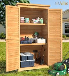 an outdoor storage shed with tools and other items in the open door, sitting on grass