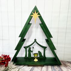 a wooden christmas tree with nativity scene on it