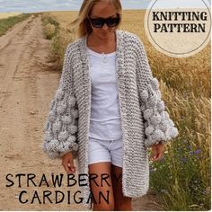 a woman in white shirt and shorts standing on dirt road with text overlay that reads knitting pattern strawberry cardigan