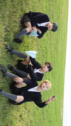 three young women in business attire laying on the grass