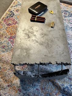 a coffee table with some pens and a cell phone on it, sitting on top of a rug