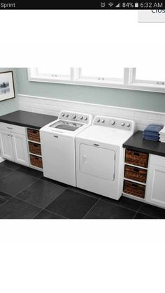 a white washer and dryer sitting next to each other in a room with black counter tops