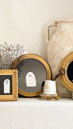 there are three framed pictures with ghost faces on the shelf next to each other,